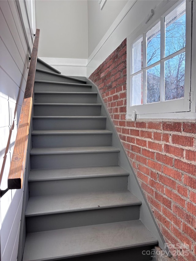 stairs featuring brick wall