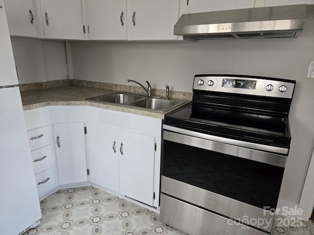 kitchen with stainless steel range with electric stovetop, sink, white fridge, and white cabinets