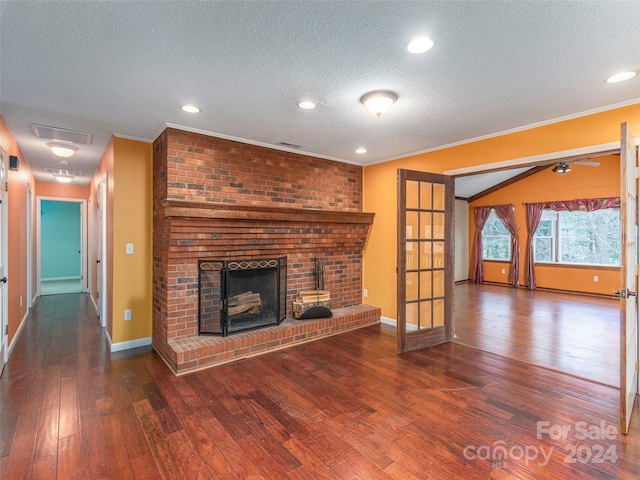 unfurnished living room featuring a textured ceiling, ornamental molding, dark wood-type flooring, and a brick fireplace