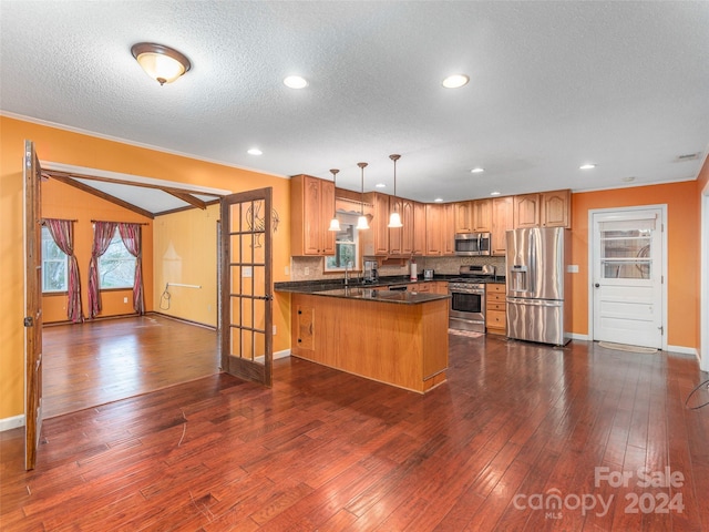 kitchen featuring dark hardwood / wood-style floors, kitchen peninsula, pendant lighting, appliances with stainless steel finishes, and ornamental molding