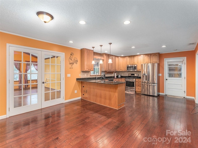 kitchen featuring french doors, stainless steel appliances, dark wood-type flooring, kitchen peninsula, and pendant lighting