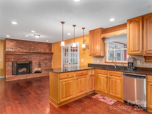 kitchen featuring stainless steel dishwasher, dark hardwood / wood-style floors, kitchen peninsula, and sink