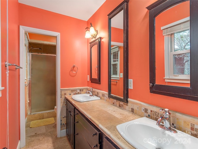 bathroom featuring tile patterned floors, vanity, tile walls, toilet, and a shower with shower door