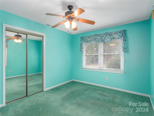 unfurnished bedroom with carpet, ceiling fan, and a closet