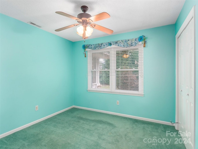 unfurnished room with ceiling fan and carpet floors