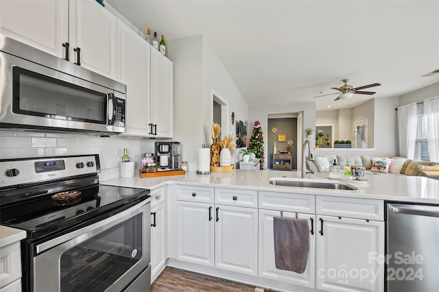 kitchen featuring white cabinets, stainless steel appliances, kitchen peninsula, and sink