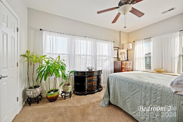 bedroom featuring multiple windows, ceiling fan, and carpet floors