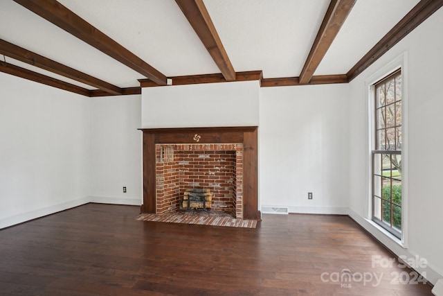 unfurnished living room with beam ceiling, dark hardwood / wood-style flooring, and a wealth of natural light