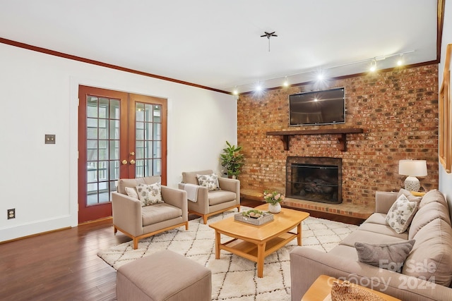 living room with french doors, rail lighting, a brick fireplace, ornamental molding, and wood-type flooring