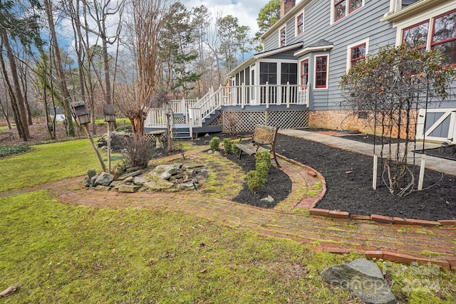 view of yard featuring a sunroom and a deck