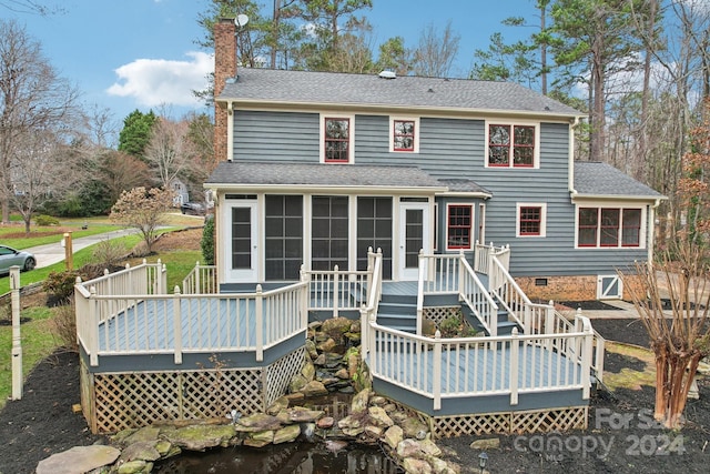 rear view of property with a sunroom and a wooden deck