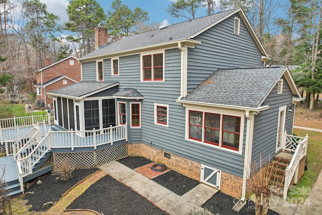 back of property with a sunroom and a deck