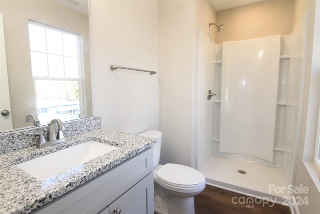 bathroom featuring walk in shower, hardwood / wood-style floors, a healthy amount of sunlight, and toilet