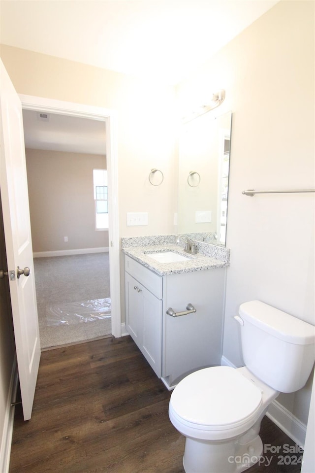 bathroom featuring vanity, hardwood / wood-style flooring, and toilet