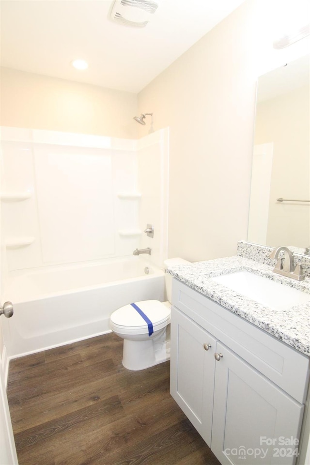 full bathroom with toilet, vanity, wood-type flooring, and tub / shower combination