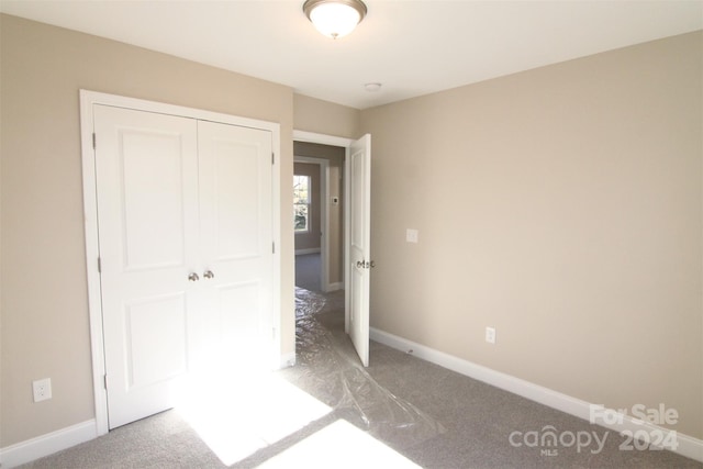 unfurnished bedroom with carpet and a closet