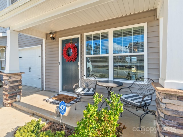 doorway to property featuring a porch and a garage