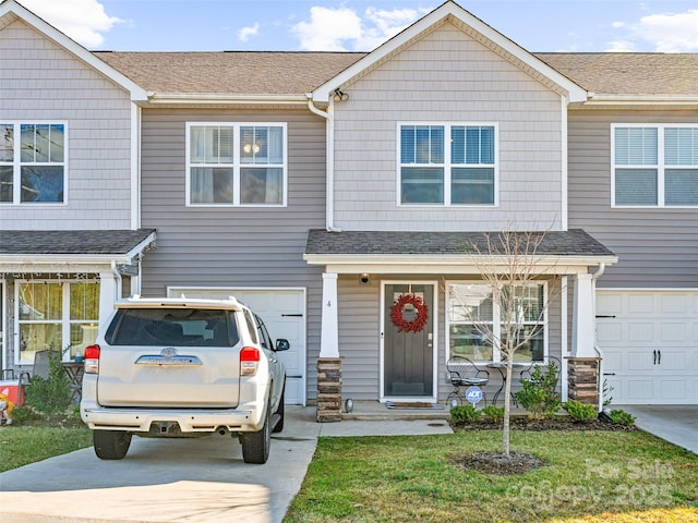 multi unit property with a garage and a front lawn