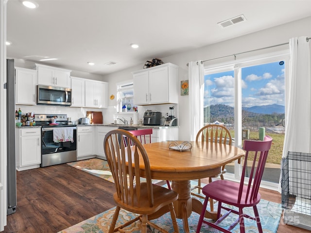 dining room with a mountain view and dark hardwood / wood-style flooring