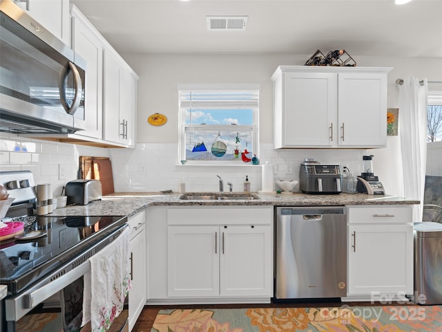 kitchen featuring white cabinetry, a healthy amount of sunlight, appliances with stainless steel finishes, and sink