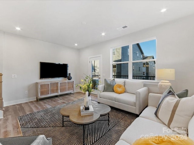 living room with hardwood / wood-style floors and a healthy amount of sunlight