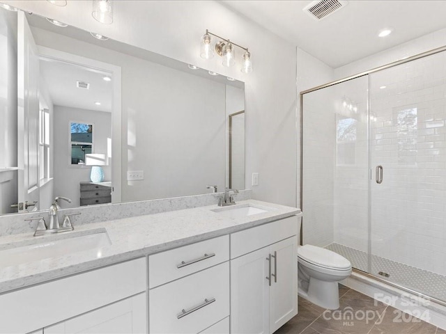 bathroom featuring tile patterned floors, vanity, toilet, and walk in shower