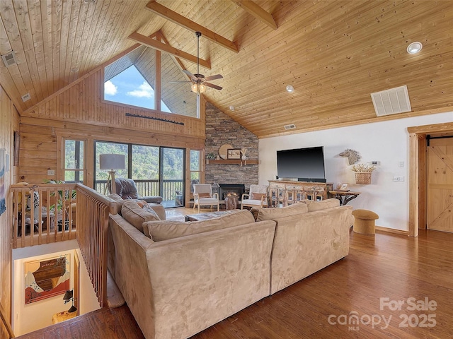 living area with wooden ceiling, high vaulted ceiling, a ceiling fan, a stone fireplace, and wood finished floors