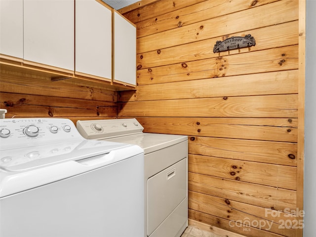 laundry room with washing machine and clothes dryer and cabinet space