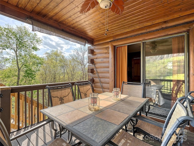wooden deck with outdoor dining space and ceiling fan
