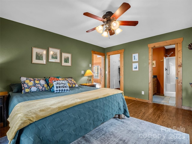 bedroom featuring wood finished floors, baseboards, a ceiling fan, and ensuite bathroom