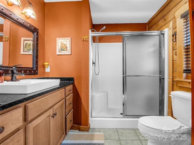 full bath with toilet, tile patterned floors, vanity, and a shower stall