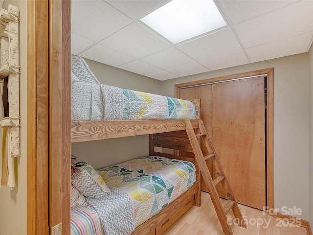 bedroom featuring a paneled ceiling and wood finished floors