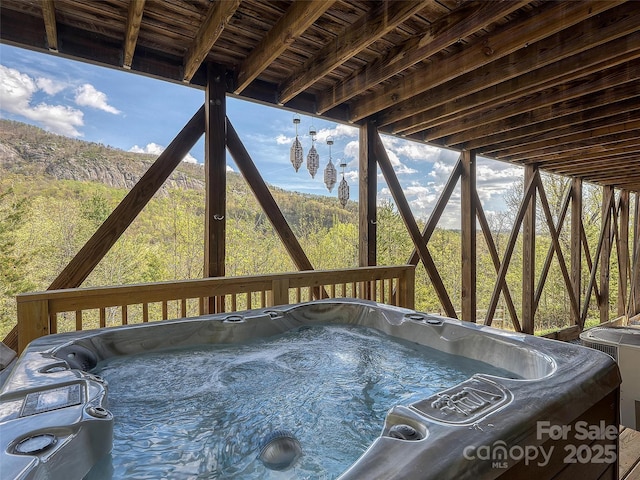 deck with a hot tub and cooling unit