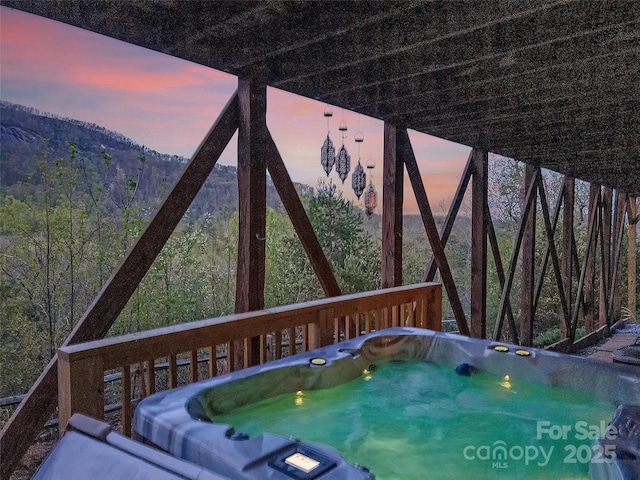 deck at dusk with a hot tub