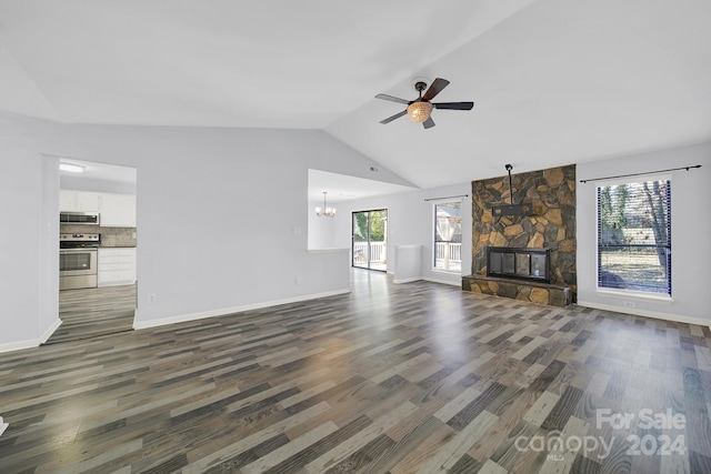 unfurnished living room featuring ceiling fan with notable chandelier, dark hardwood / wood-style flooring, a fireplace, and vaulted ceiling