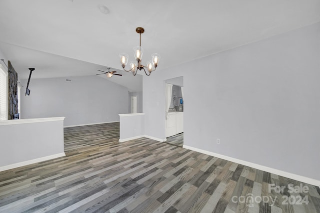 interior space featuring ceiling fan with notable chandelier, dark wood-type flooring, and vaulted ceiling