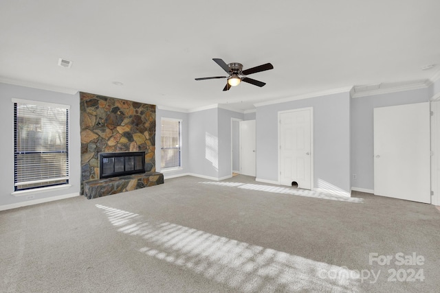 unfurnished living room featuring a fireplace, light carpet, ceiling fan, and ornamental molding