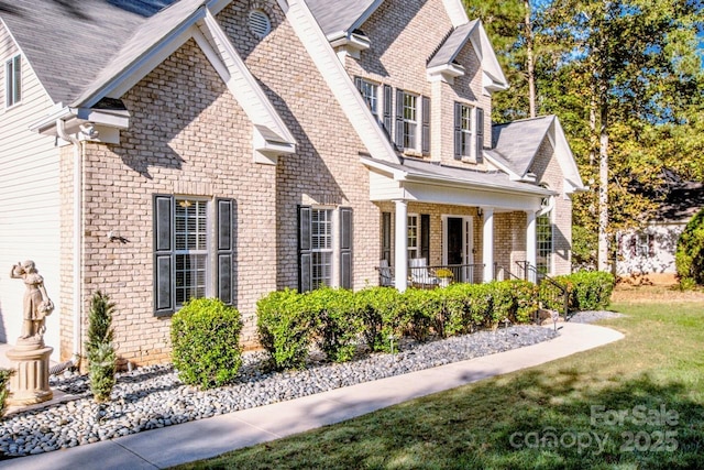 view of property exterior featuring a porch and a lawn