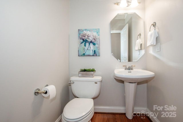 bathroom featuring wood-type flooring, toilet, and sink