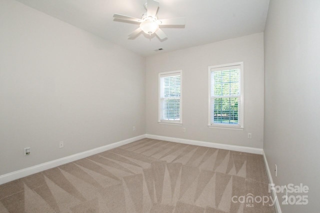 carpeted spare room with ceiling fan