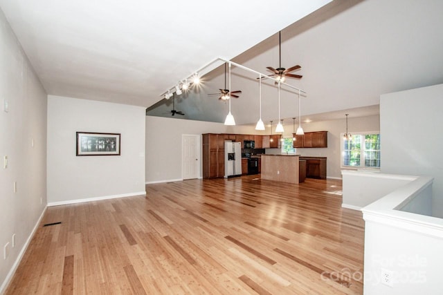 unfurnished living room with ceiling fan, track lighting, and light wood-type flooring