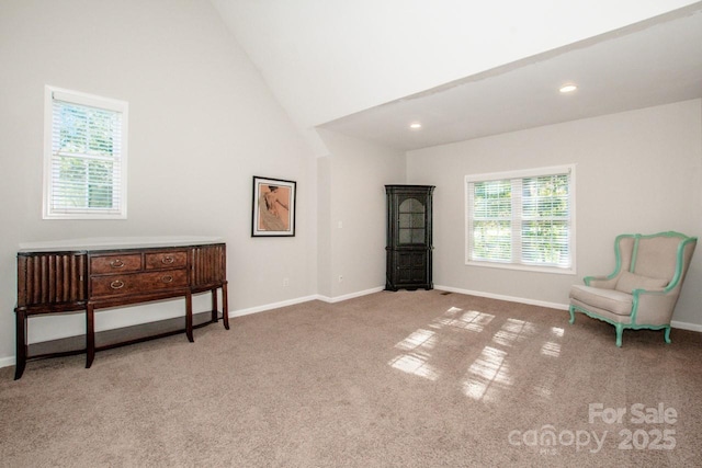 living area with light colored carpet and high vaulted ceiling