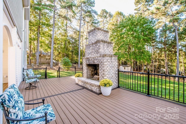 wooden terrace with an outdoor brick fireplace and a yard