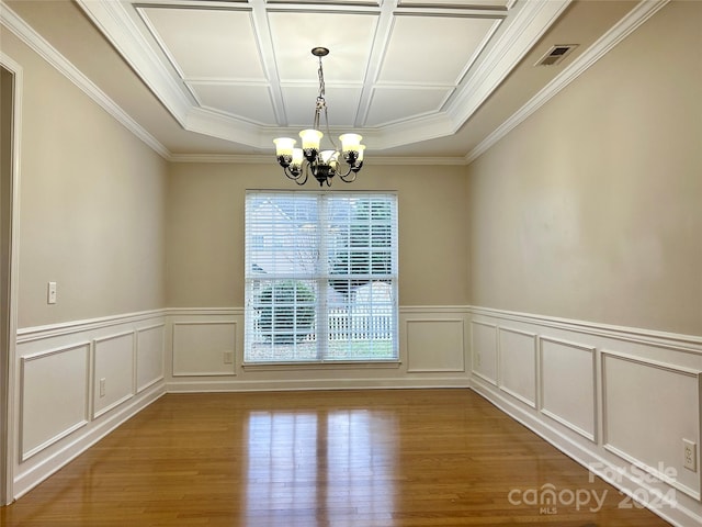 unfurnished dining area featuring hardwood / wood-style flooring, crown molding, and an inviting chandelier