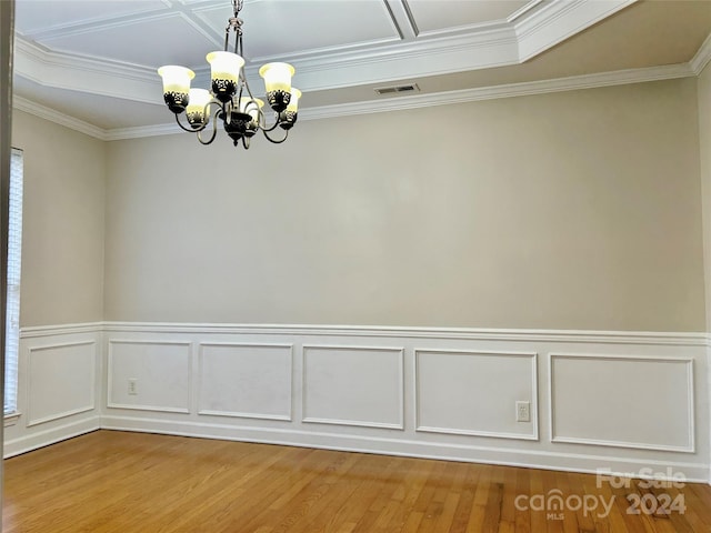 unfurnished room with wood-type flooring, ornamental molding, and an inviting chandelier