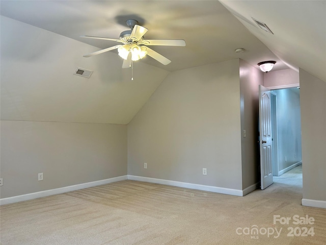 additional living space featuring light carpet, vaulted ceiling, and ceiling fan