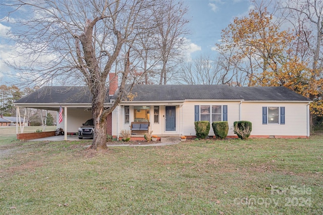 ranch-style home featuring a front lawn and a carport