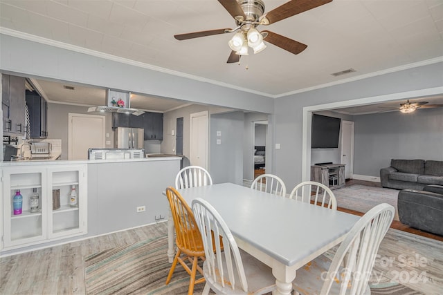 dining area featuring light hardwood / wood-style floors and crown molding