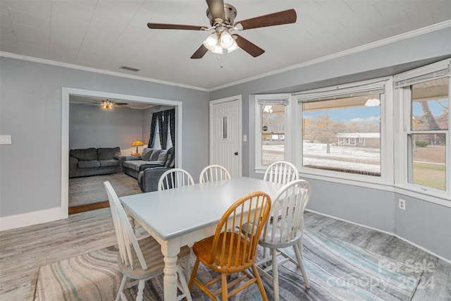 dining room with light hardwood / wood-style floors, ceiling fan, and ornamental molding