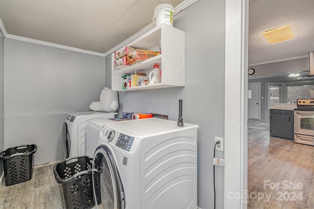 laundry area with wood-type flooring, ornamental molding, and independent washer and dryer